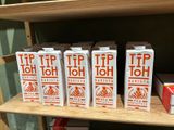 five boxes of orange juice on a shelf in a store