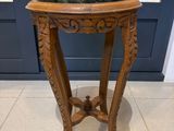 une petite table en bois avec un plateau en marbre, posée sur un sol carrelé