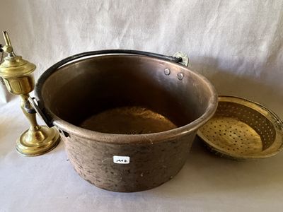 une grande marmite en métal munie d'une passoire et d'un robinet en laiton