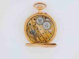 a gold pocket watch on a white surface with a white background