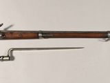 un vieux fusil avec un canon en bois et une poignée en métal
