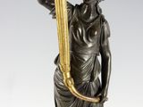 a bronze statue of a woman holding a torch in her hand