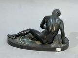 statue of a seated male nude on a marble base