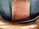 brown leather bag with a zippered pocket on the inside of it