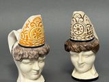 pair of ceramic figurines of heads with hats on them