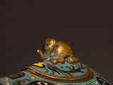 a blue and gold teapot with a cat on top of it