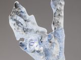 a blue and white sculpture of a cat on a rock