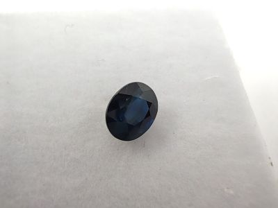 a blue sapphire stone sitting on top of a white surface