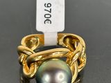 a close up of a ring with a black pearl on it