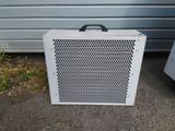 a small white box sitting on the ground next to a garage door