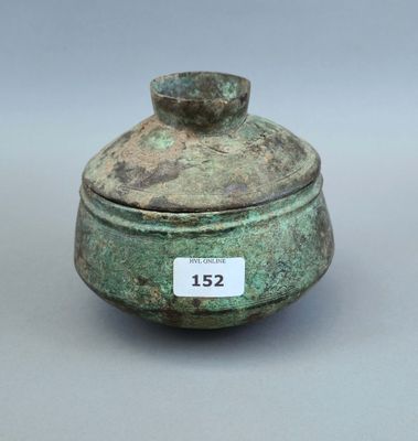 un petit pot vert muni d'une étiquette