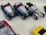 several toy cars are lined up on a table next to a calculator