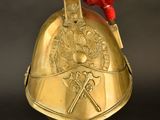 a gold helmet with a red feather on top of it