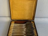 un ensemble de six cuillères en métal argenté dans un coffret en bois