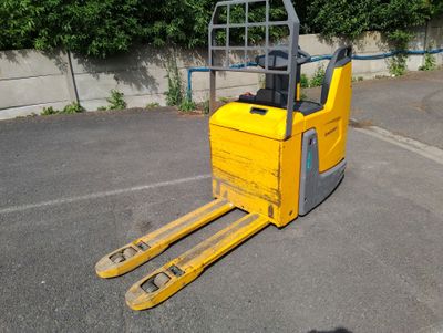un chariot élévateur jaune garé sur un parking