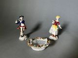 two figurines of a man and a woman standing next to each other