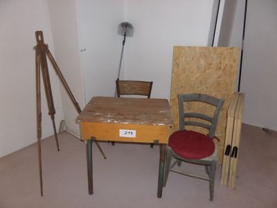 a desk with a chair and easel in the corner of a room