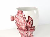 une tasse blanche avec une fleur rose à l'intérieur