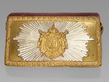 an image of a gold and silver belt buckle with a sunburst on it