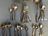 a lot of silver spoons and spoons on the table