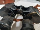 a pair of binoculars sitting on a table next to a bag