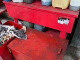 a red work bench with a lot of bottles of oil