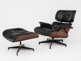 a black leather lounge chair and ottoman on a white background