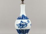 une photo d'un vase bleu et blanc avec une chaîne, posé sur une table