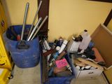 a blue trash can filled with assorted items in a room