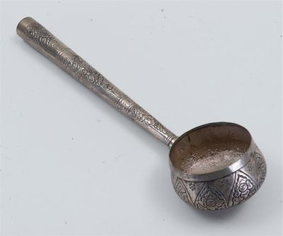 an old spoon with a metal handle sitting on a white surface