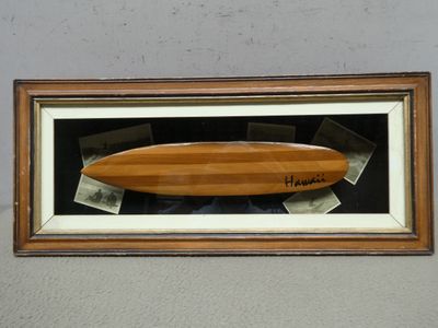 une photo d'une planche de surf en bois exposée dans une vitrine