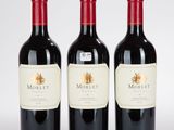 trois bouteilles de vin rouge posées l'une à côté de l'autre sur une surface blanche