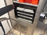 a machine that is sitting in a kitchen with orange bins on it