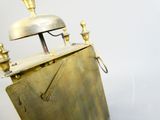 une horloge en or surmontée d'une cloche