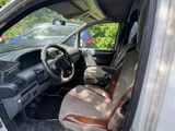 the interior of a car with the door open and the driver ' s seat down