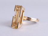 un gros plan d'une bague en or sertie d'une grosse citrine