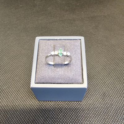 bague en argent massif sertie d'une pierre verte, présentée dans un coffret cadeau
