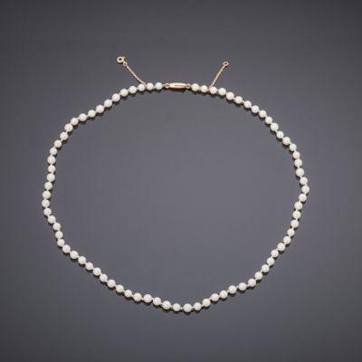 a white pearl necklace with a gold clasp