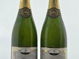 deux bouteilles de champagne posées sur une table l'une à côté de l'autre