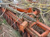 un tracteur immobilisé dans l'herbe, avec une charrue attelée derrière lui