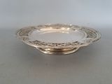 a close up of a silver plate on a table with a white background