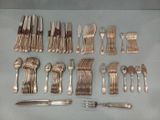 a lot of silverware on a table with a knife and fork