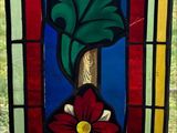 a stained glass window with a flower and a bird on it