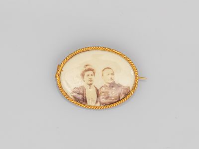 une vieille photo de deux personnes dans un cadre doré