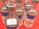 six bouteilles de vodka Absolut posées sur une table rouge