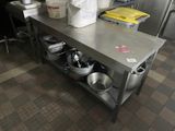 a kitchen with a large table with pots and pans on it