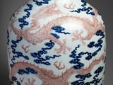 a vase with a dragon design on it sitting on a table