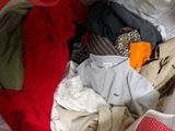 a pile of clothes that is sitting on a bed