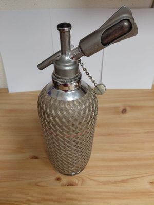 a metal bottle with a metal handle on a wooden table