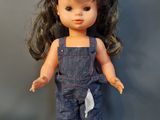 a doll that is wearing a denim overalls and white shoes